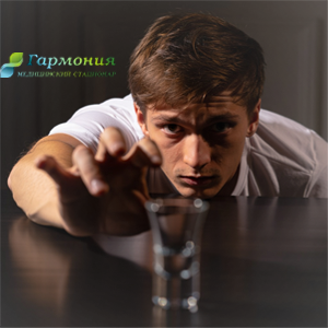 Мужчина тянется к рюмке